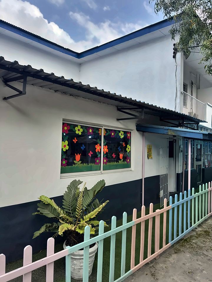 Classroom window decorated with bright paper flowers and butterflies