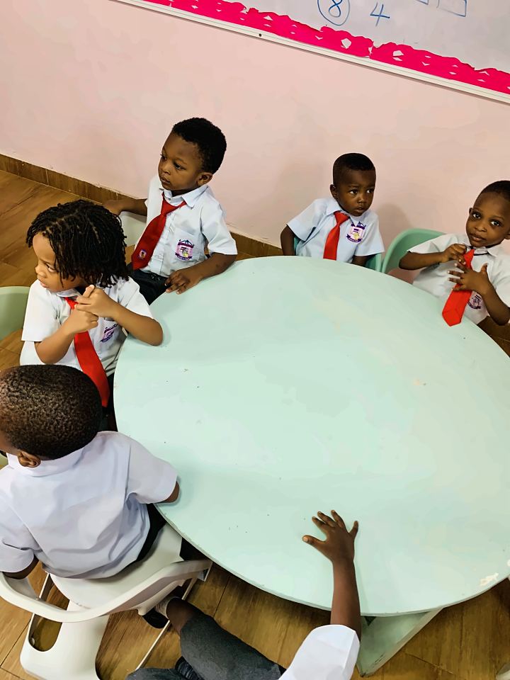 Nursery pupils seated around a round table in a bright classroom